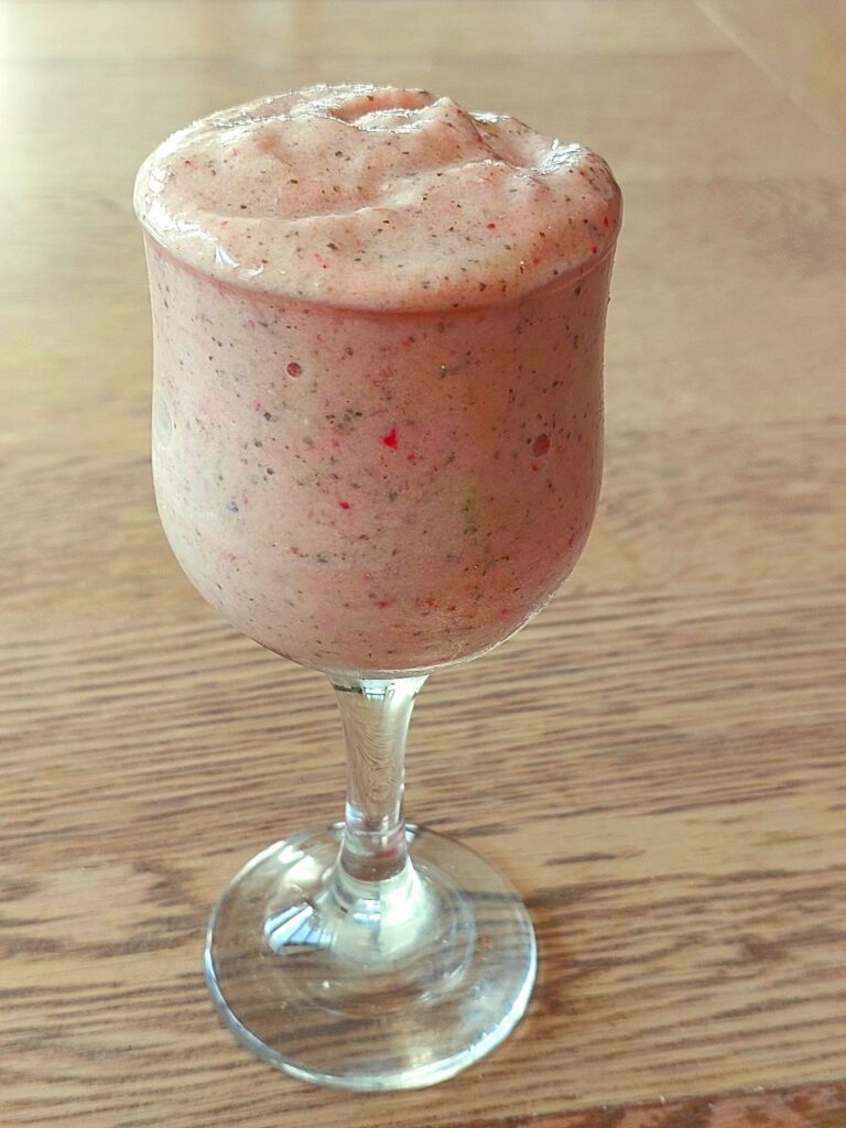 כוס זכוכוית מלאה בשייק פירות עם חלבון בריא